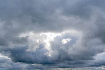 Obraz premium The sun shines through a hole in the imposing clouds above the Normandy coast