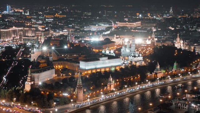 Close up view from above to Moscow Kremlin at night, beautifully illuminated with evening lights and surrounded by streets with busy traffic, all in motion timelapse.