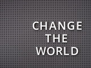 Phrase Change the World spelled out with white letters on gray pegboard