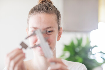 Junge Frau als Technikerin misst mit Werkzeug