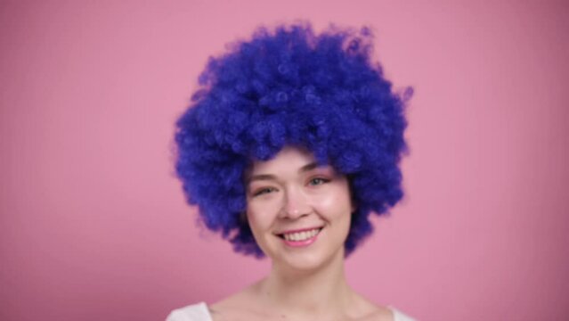 Close-up Portrait of Young Smiling Woman In blue Wig. Millennial female with blue curly hair.