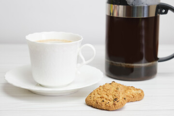 White porcelain cup with coffee, French press and homemade cookies. Homemade cakes for breakfast