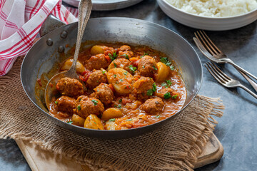 Sausage meatballs and potatoes in curry sauce with rice