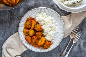 Sausage meatballs and potatoes in curry sauce with rice