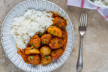 Sausage meatballs and potatoes in curry sauce with rice