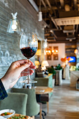 oung girl holding glass goblet with red wine or merlot