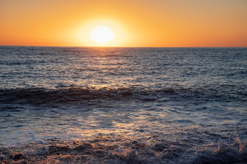 The sea wave. Sunset in the sea. The power of the elements.