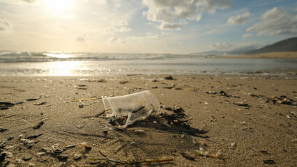 Used Plastic cup discarded on sea coast ecosystem,nature pollution contamination