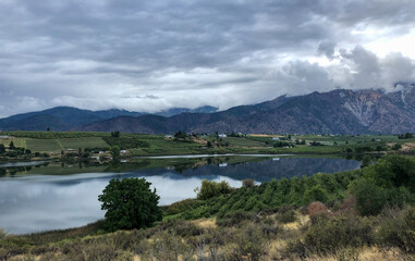 Fototapeta na wymiar Mountains, vineyards and farms surround Dry Lake near Manson in Eastern Washington State. 