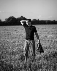 handsome man with short bristles in a black T-shirt in a beveled field. Black and white