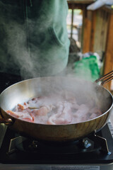 Bacon frying in pan with steam, outdoors, camping 