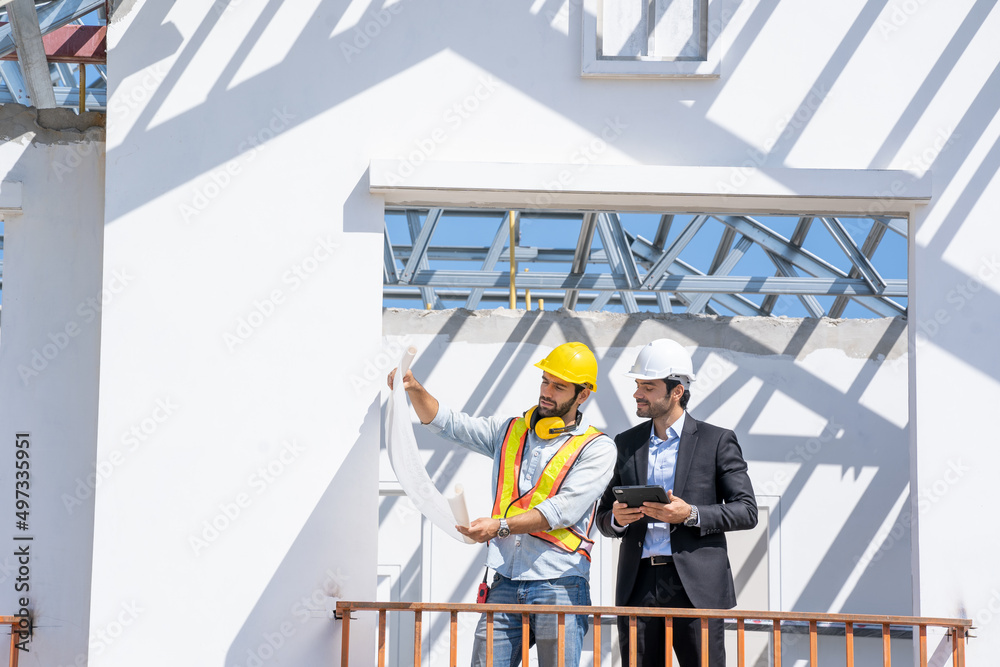 Poster engineer with business manager are talking in construction site,project owner with blueprint working