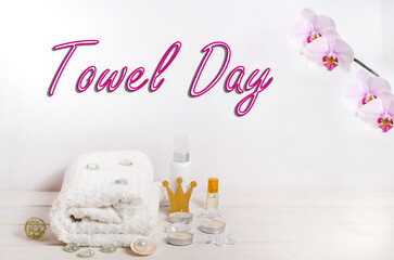 Towel day lettering, white towel with pink hearts on a white wooden background