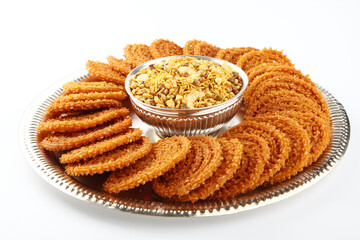 Traditional indian snack - chakali & Chivada in sliver tray isolated on white.