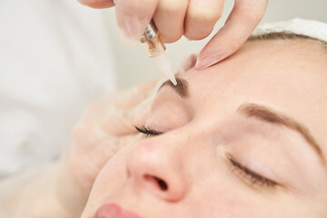 Permanent makeup. Beauty spa procedure. young woman. Face tattoo. Eye micropigmentation. Professional face microblading. Female cosmetology device. Copyspace. Mouth treatment. Dermatology