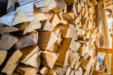 Chopped and chopped firewood stacked and harvested for the winter in a firewood shed. Storing firewood in summer