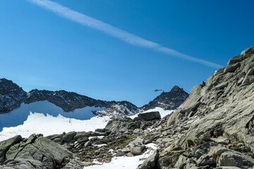 Obraz premium Rescue helicopter flying over Hoher Sonnblick glacier in High Tauern mountains in Carinthia, Salzburg, Austria, Europe, Alps. Goldbergkees in Hohe Tauern National Park, sunny day. Kleinfleissscharte