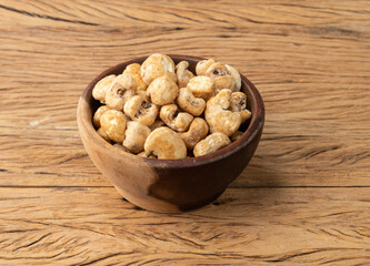 Canjica, hominy or white corn popcorn, sweet popcorn in a bowl over wooden table