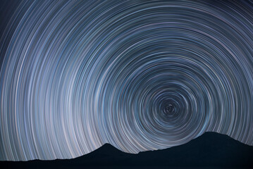 Night landscape, star trails over the mountains. 