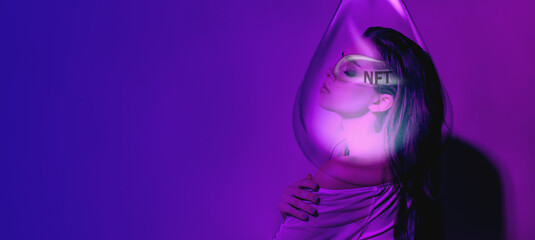 A young girl in neon pink light thinks through the NFT token. Modern views and income. NFT cryptography concept.