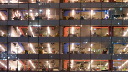 Glass wall of an office building with depersonalized interiors behind glass