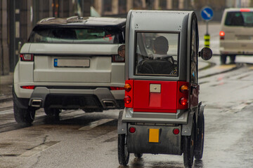 Fototapeta na wymiar Small electric car in streets of Zurich town in rainy spring day