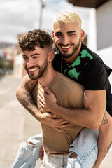 Portrait of a happy gay couple having fun on an outdoor date, playing together, smiling. Real...