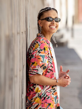 Happy Smiling Young Hispanic Woman Posing On The City Street . Girl Wearing Fashionable Shirt, Sunglasses And A Lot Of Jewelry.