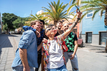 Group of happy multicultural friends taking selfie and having fun together, laughing. City street....