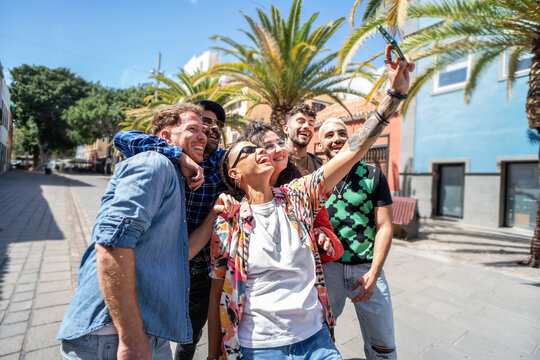 Group of happy multicultural friends taking selfie and having fun together, laughing. City street. Friendship. Real people emotions. Tourism.