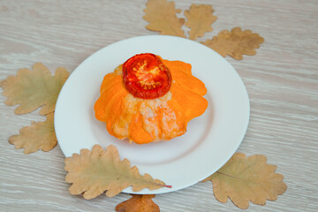 Baked patisson with tomato cheese. Pumpkin zucchini stuffed with meat on a white plate.