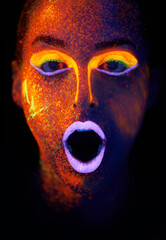 Bright and colourful. A young woman with with neon paint on her face.