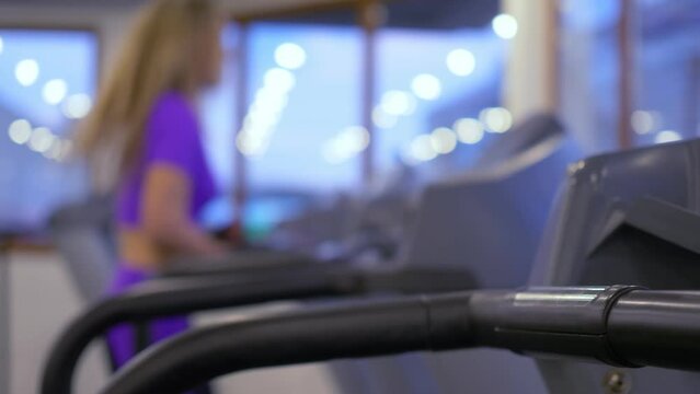 Blurred view of young women running on the treadmill at gym