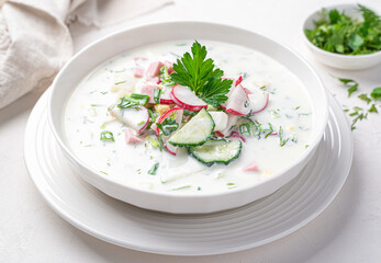 Summer, cold soup with vegetables, sausage, kefir and fresh herbs.