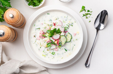 Cold vegetable soup okroshka on a white background.