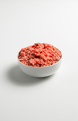 Fototapeta na wymiar Plate with fresh ground beef on a white background, space for text, stock photo