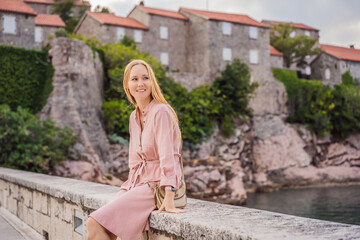 Woman tourist on background of beautiful view of the island of St. Stephen, Sveti Stefan on the Budva Riviera, Budva, Montenegro. Travel to Montenegro concept