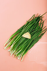 green fresh chives on a pink background. dumpling laid out on top