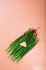 green fresh chives on a pink background. dumpling laid out on top