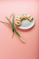 dumplings in a plate on a pink background