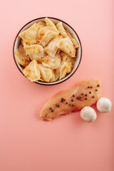 dumplings in a plate on a pink background