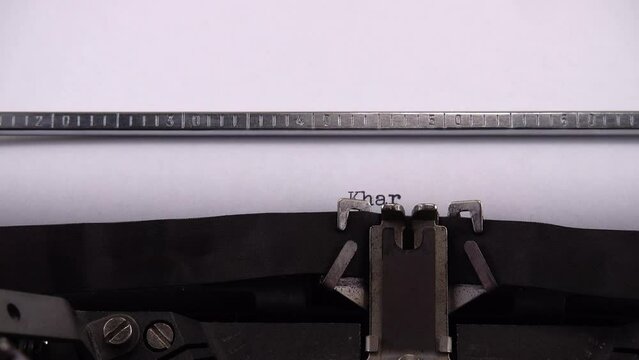Typing name of Ukrainian city Kharkiv on retro typewriter.