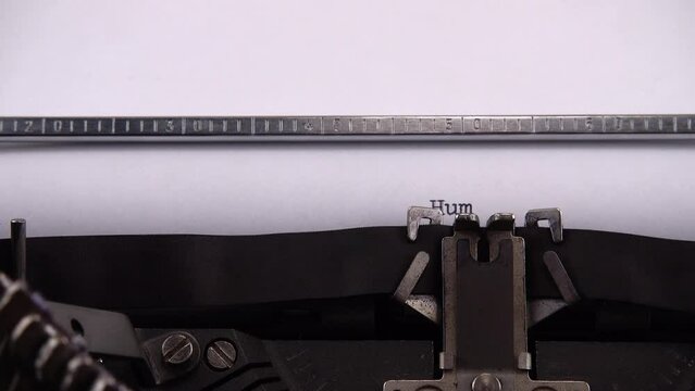 Typing phrase Humanitarian crisis on retro typewriter.