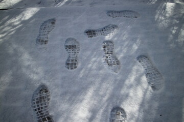 footprints in the snow on the street on a winter morning