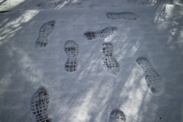footprints in the snow on the street on a winter morning