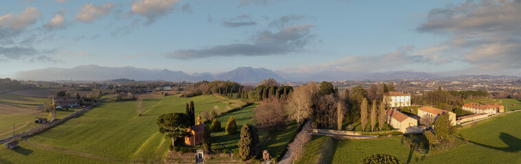 Obraz premium Aerial drone shot. Red church of Pomelasca at sunset - Lombardy countryside