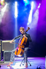 Young woman playing cello on the concert at night