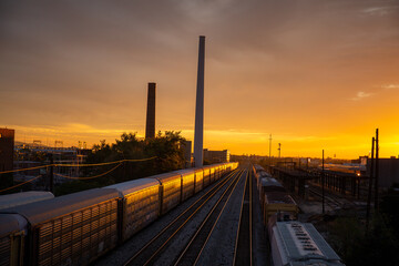 Fototapeta na wymiar Sunset reflects on passing train cars 