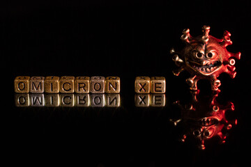 XE. A new variant of SARS-CoV-2 coronavirus. Omicron sub variant. Viral gold color on a black...