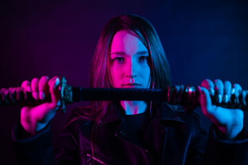 Cyber girl in a black leather jacket at dusk holds a katana. A woman in a club with a colored...